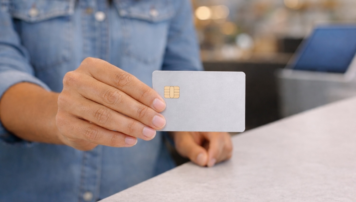 Woman using a credit card to make a purchase at a POS counter